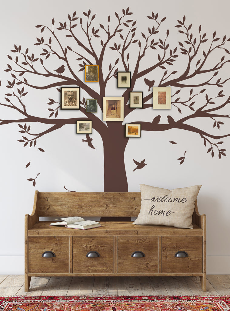 Large brown tree wall decal with spreading branches and leaves, adorned with family photos in frames. Wooden bench with drawers below. Rustic welcome pillow and colorful rug complete cozy entryway scene. Featured Collection,Top Sellers,Wall Decals,Family Tree Decals,Tree Decals,All Products