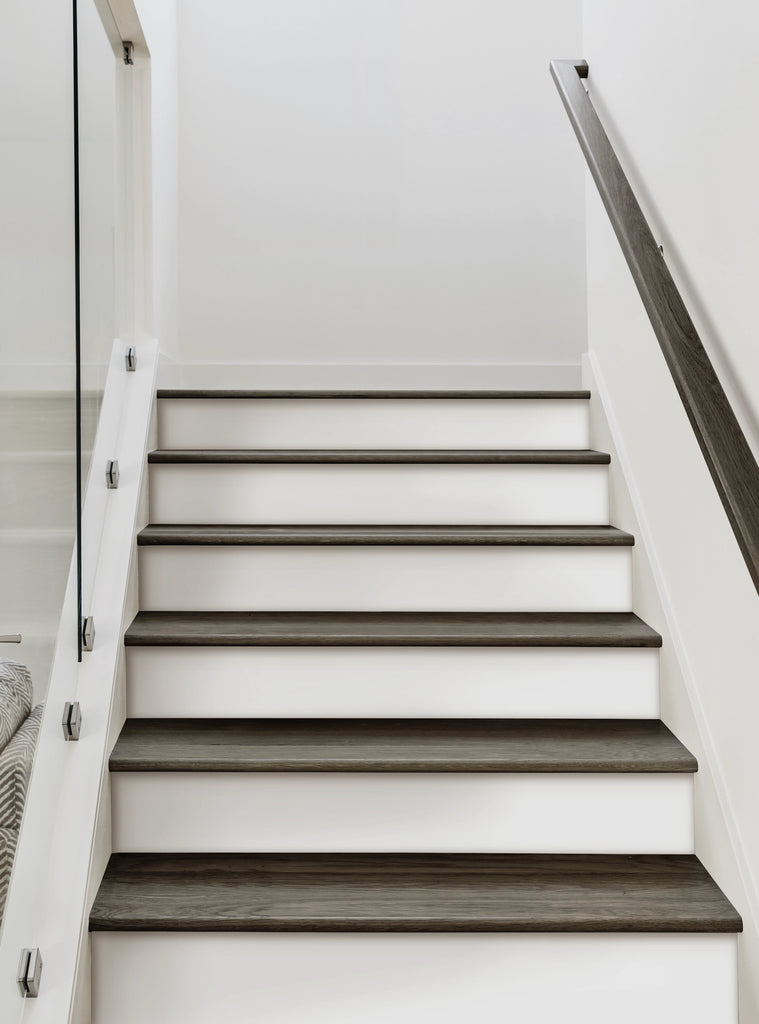 Modern white staircase with dark wood treads and white risers, perfect for applying peel and stick stair riser strips. Clean, minimalist design ideal for home renovation and DIY projects. Easy to install and remove decorative stair decals for a fresh look. Top Sellers,Stair Riser Decals,All Products