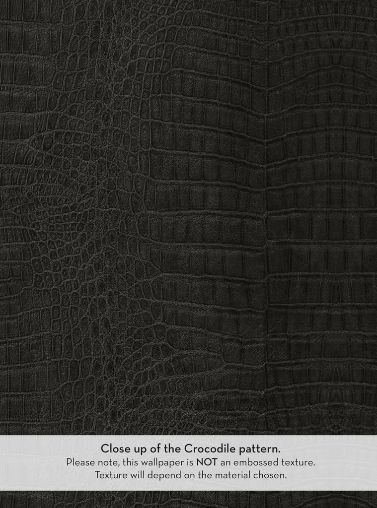 A close-up view of black crocodile-patterned wallpaper, showcasing the intricate texture and design. The pattern features various scales and textures typical of crocodile skin. A note at the bottom clarifies that the wallpaper is not embossed and that the texture will depend on the chosen material. The overall appearance highlights the sophisticated and luxurious feel of the design.